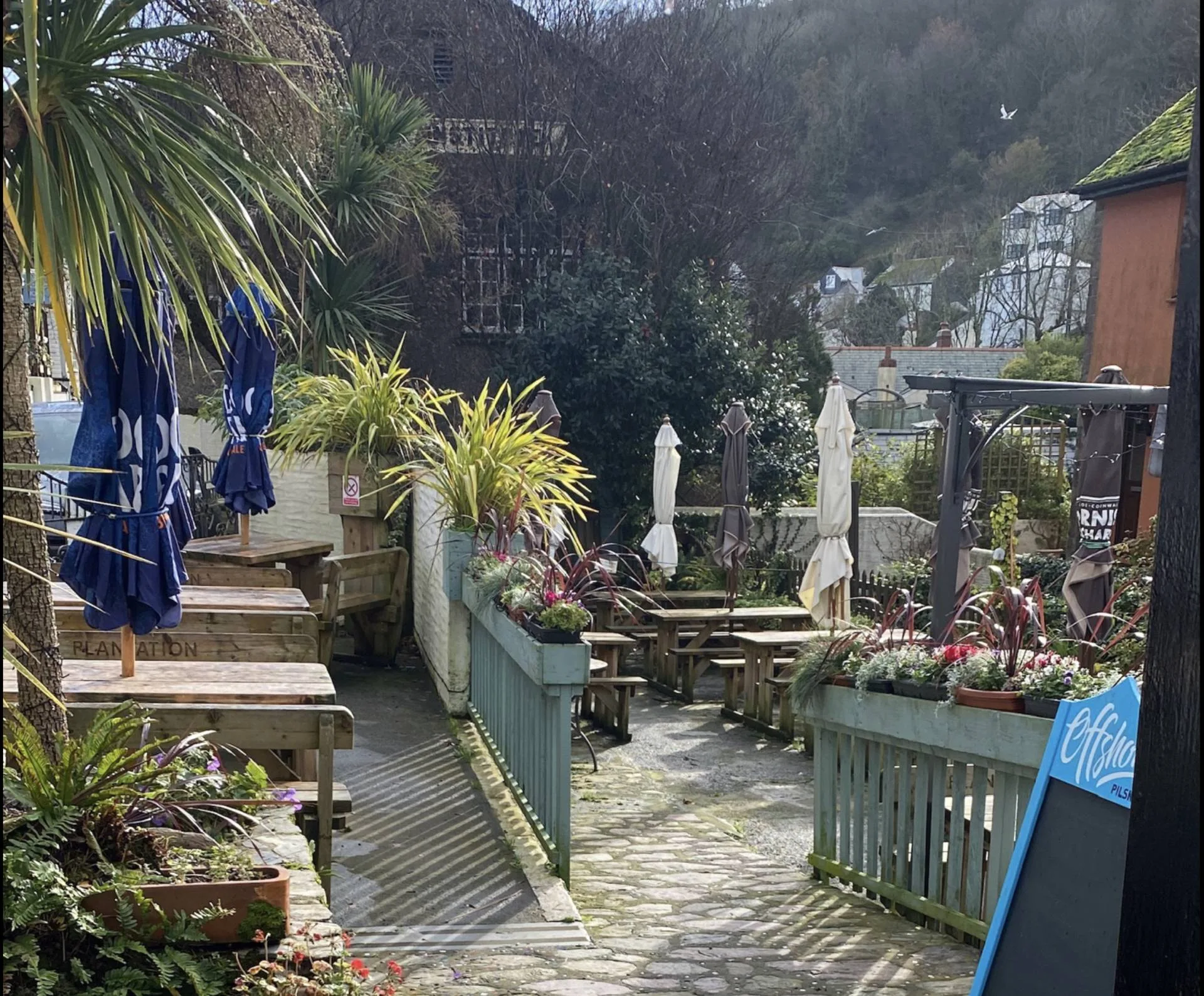 Outdoor tables along the planted garden path at The Plantation Tearooms